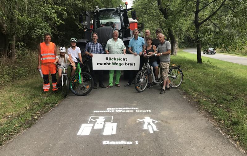 Mit Sprühkreide oder Sprühfarbe und einer Schablone werden der Appell „Rücksicht macht Wege breit“ und symbolisch ein Traktor und ein Radfahrer auf Feld- und Wirtschaftswegen aufgebracht, wie hier in Eberstedt im Weimarer Land. 